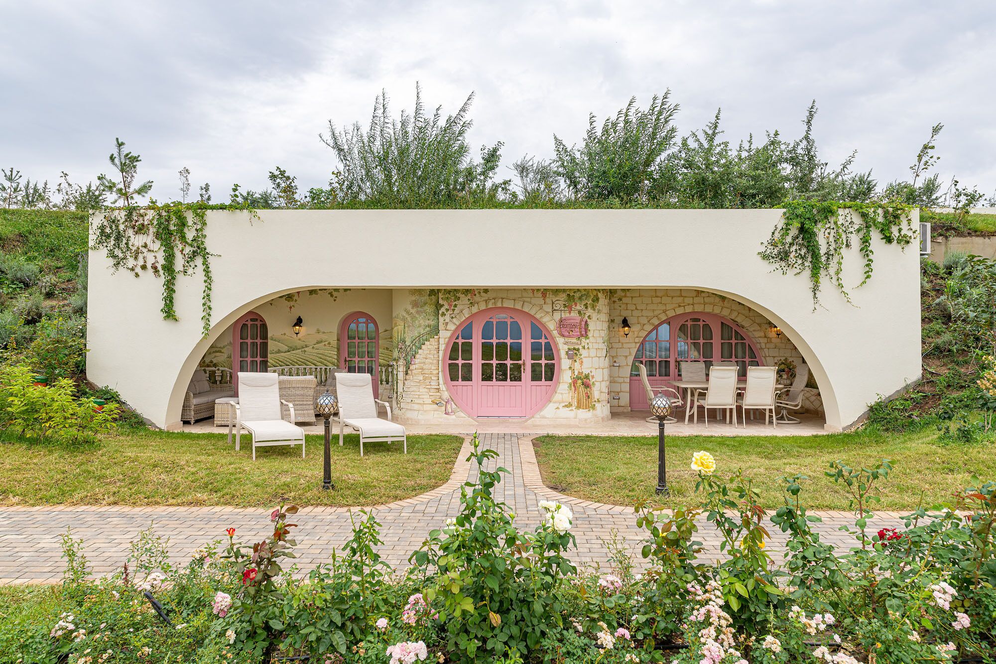 A building with arched windows and a covered patio area with seating.