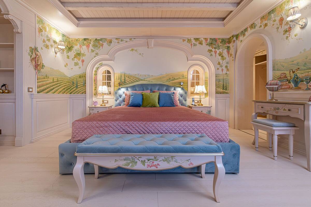 A bedroom with a large bed, a dresser, and a desk.