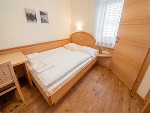 A single bed with a wooden headboard, a bedside table, and a small shelf. - In the Center of Neustift - TWO Bedroom Apartment - sleeps 6 (Neustift im Stubaital)
