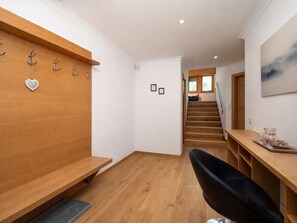 A modern interior with a wooden bench, a black chair, a staircase, and a wooden desk with a glass container. - In the Center of Neustift - TWO Bedroom Apartment - sleeps 6 (Neustift im Stubaital)
