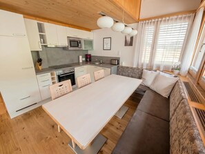A modern kitchen with white cabinets, a dining table, and a sofa. - In the Center of Neustift - TWO Bedroom Apartment - sleeps 6 (Neustift im Stubaital)