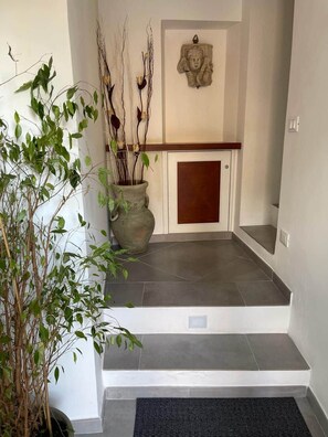 A staircase leading to a door with a decorative wall piece above it. - Cathedral House Design (Palermo)