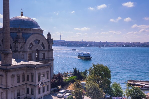 A historic building with a dome and minaret, a waterfront view, and a clear sky. - Top Floor 3BR Apartment · Bosphorus & Palace View · Central Beyoğlu (Beyoglu)