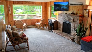Una habitación acogedora con chimenea, paredes de madera y televisión.