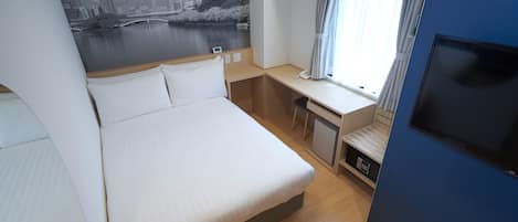 A hotel room with a bed, desk, and TV.