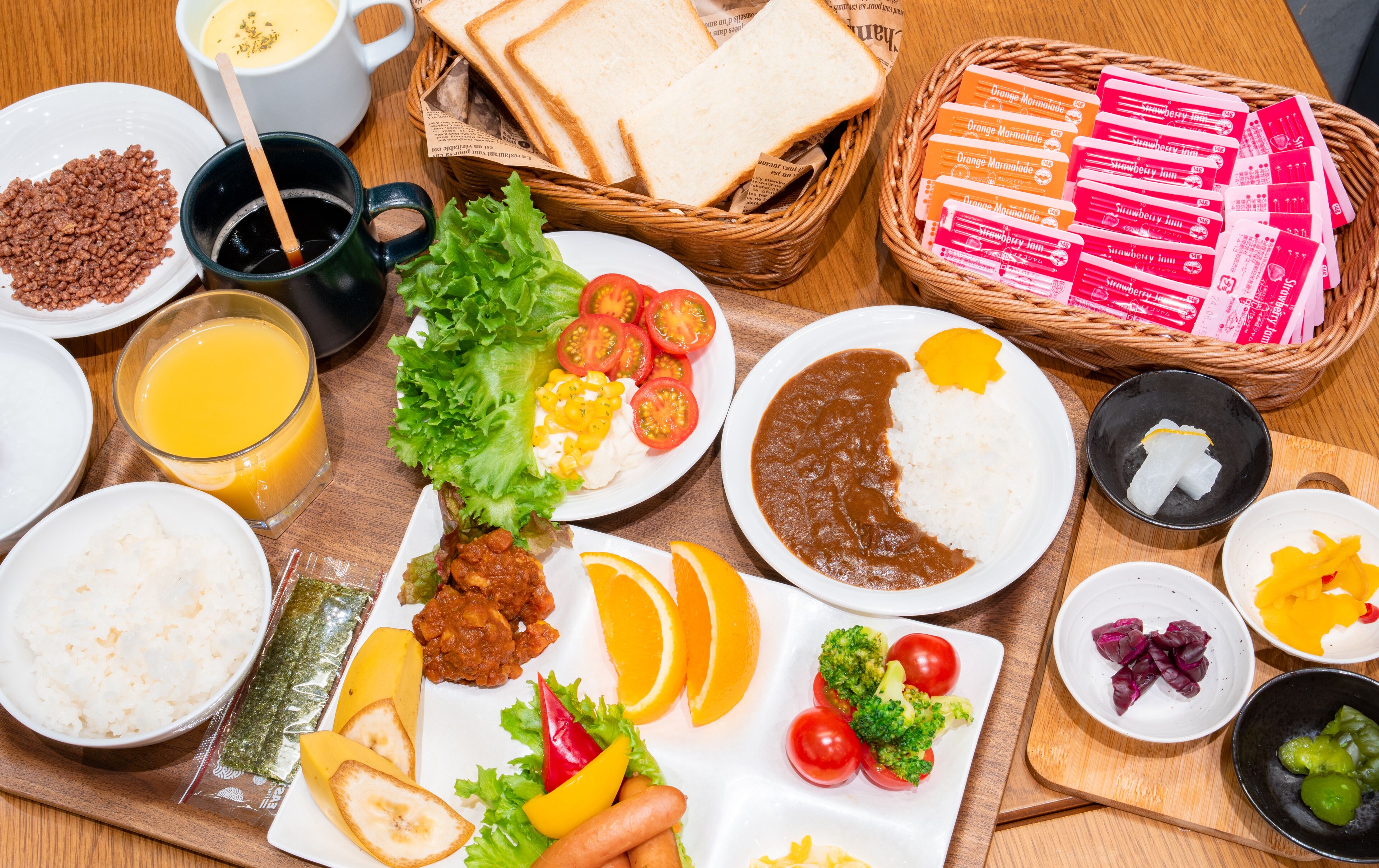 Variedad de alimentos, como arroz, frijoles y verduras, sobre una mesa de madera.