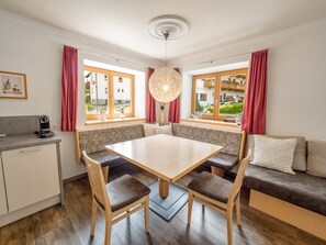 Uma cozinha moderna com uma mesa de jantar, cadeiras e um banco embutido.