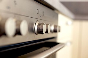 Een keuken met een roestvrijstalen afzuigkap en een ingebouwde oven.