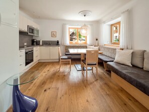 Eine moderne Küche mit Essbereich, Holzboden und Blick ins Freie.