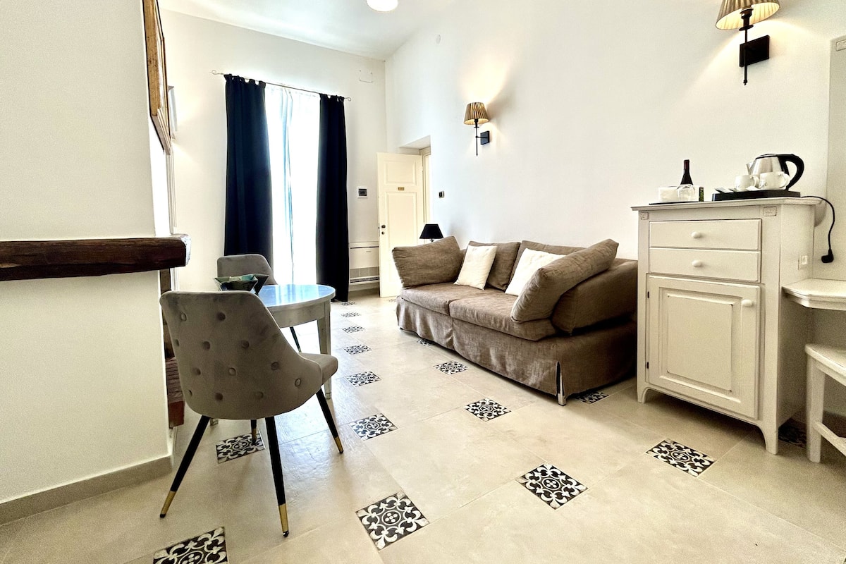 Comfort suite, 1 kingsize bed met slaapbank, terras, uitzicht op tuin | Woonruimte | Een ledtelevisie en boeken
