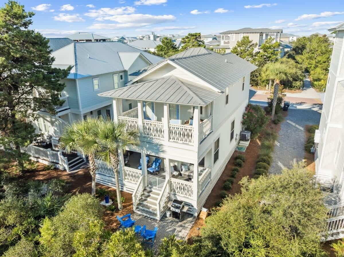 A two-story house with a balcony, a covered porch, and a paved driveway.