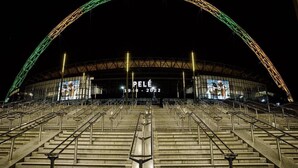 Tyhjä stadion, jossa on suuri kaarimainen rakennelma ja keskellä sijaitseva digitaalinen näyttö.