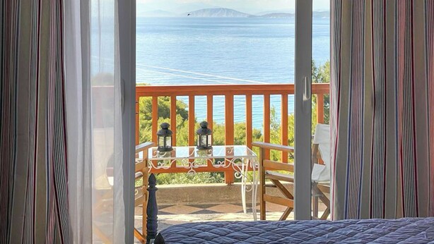 Een balkon met uitzicht op zee en bergen.