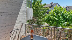 A balcony with a table and chairs, a bottle of wine, and a plate of food. - Mandorli 1/18 Apartment by Wonderful Italy (Desenzano del Garda)