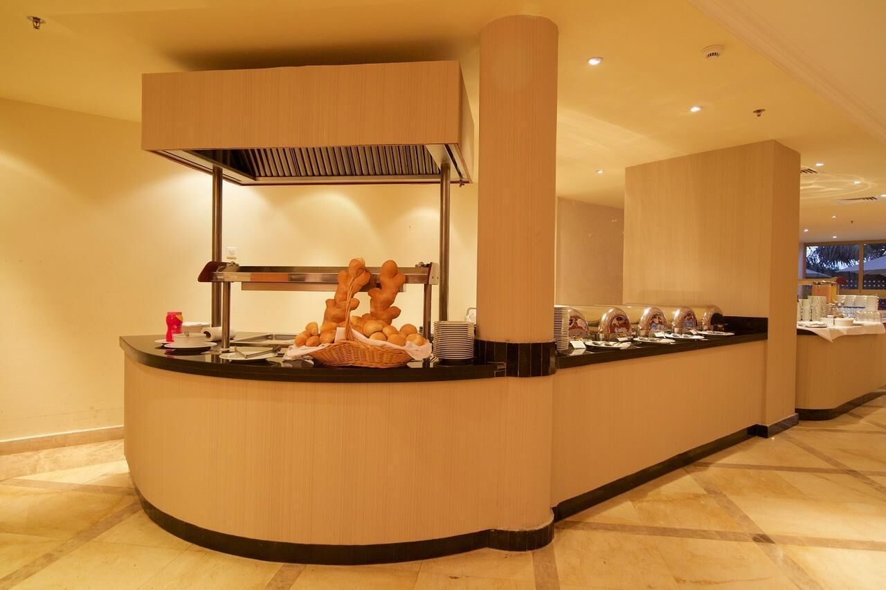 A buffet counter with a variety of food items and a coffee station.
