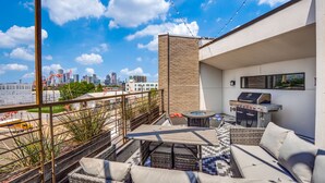 A rooftop terrace with a grill, seating area, and a view of the city skyline. - Modern 4 Story Townhome -5 minutes walk to Deep Ellum & Fair Park! (Dallas)