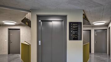 An elevator with a sign listing room numbers and their corresponding floor levels.