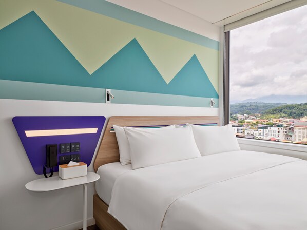 A modern hotel room with a bed, a nightstand, a wall-mounted phone, and a window with a city view. - Tru by Hilton Lao Cai City Riverside (Lao Cai)