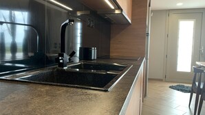 Eine moderne Küche mit Edelstahlgeräten, einer Granit-Arbeitsplatte und Holzschränken.