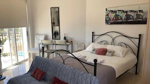 A bedroom with a bed, a sofa, a desk, and a chair.