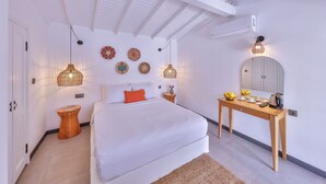 A modern bedroom with a large bed, bedside tables, a wooden dresser, a mirror, and decorative wall art. - Caliza Alacati (Cesme)