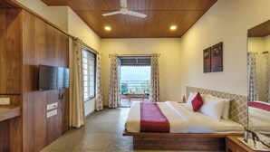 A hotel room with a bed, a TV, a ceiling fan, and a view of the outside. - CosmicStays GreyStone Villa Mountain View & Dam (Paud)
