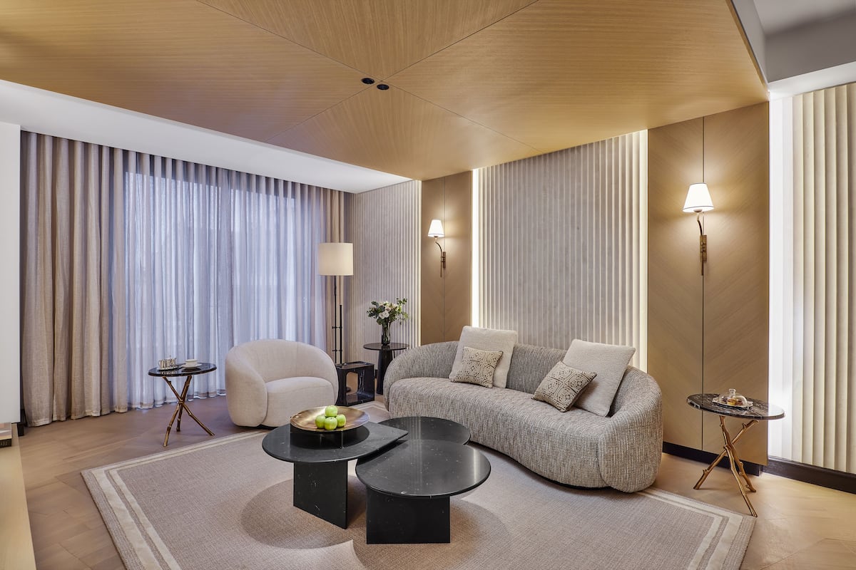 A modern living room with a sofa, two side tables, a coffee table, and a lamp.