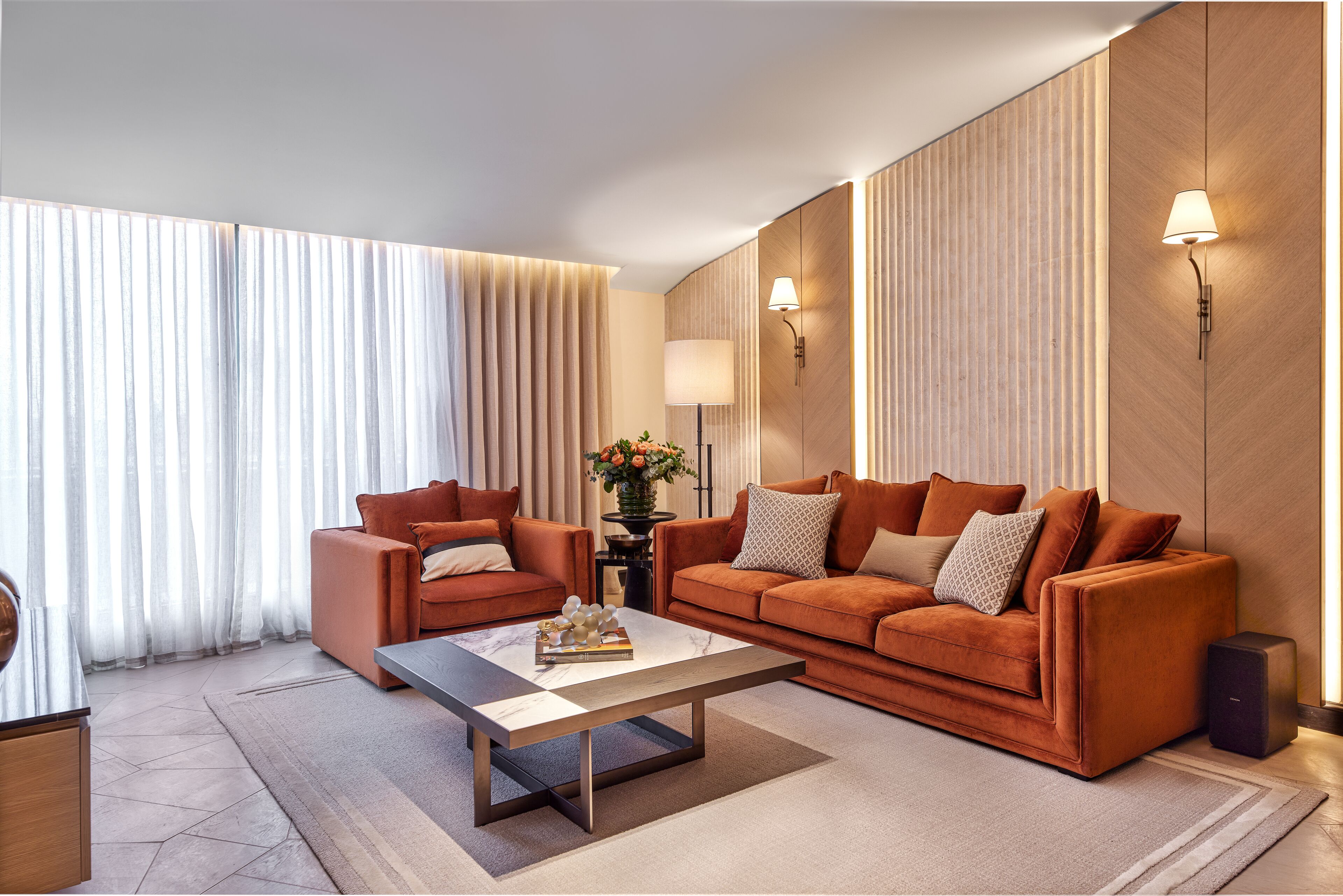 Un salon moderne avec un canapé, une table basse et une lampe.