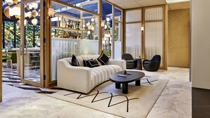 A modern living room with a sofa, a coffee table, and a bar area with shelves of bottles. - Vakko Hotel and Residence (Istanbul)