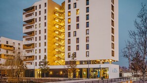 Un hotel moderno con un llamativo letrero 'eklo', varios pisos y una escalera dorada distintiva.