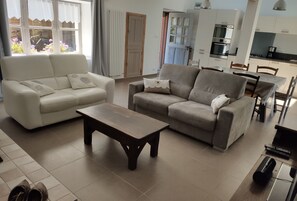 Relax in this stylish living room with two sofas, a coffee table, and a dining area.
