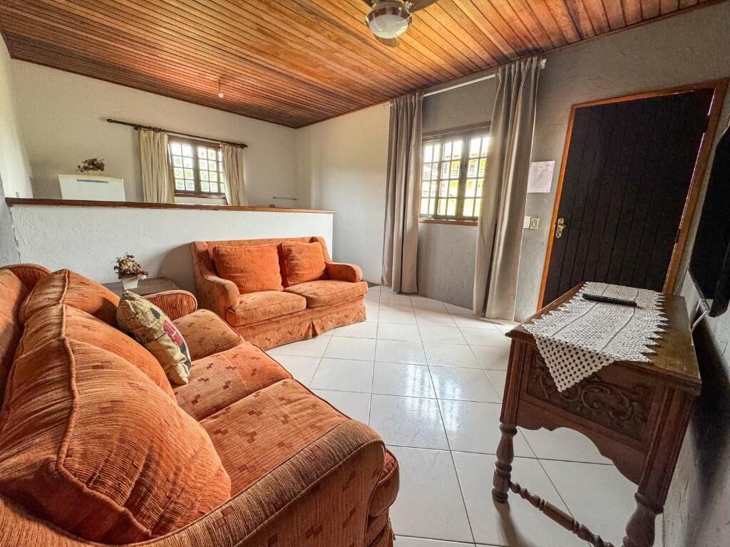 Una sala de estar con dos sofás naranjas, una mesita de madera y un espejo grande.