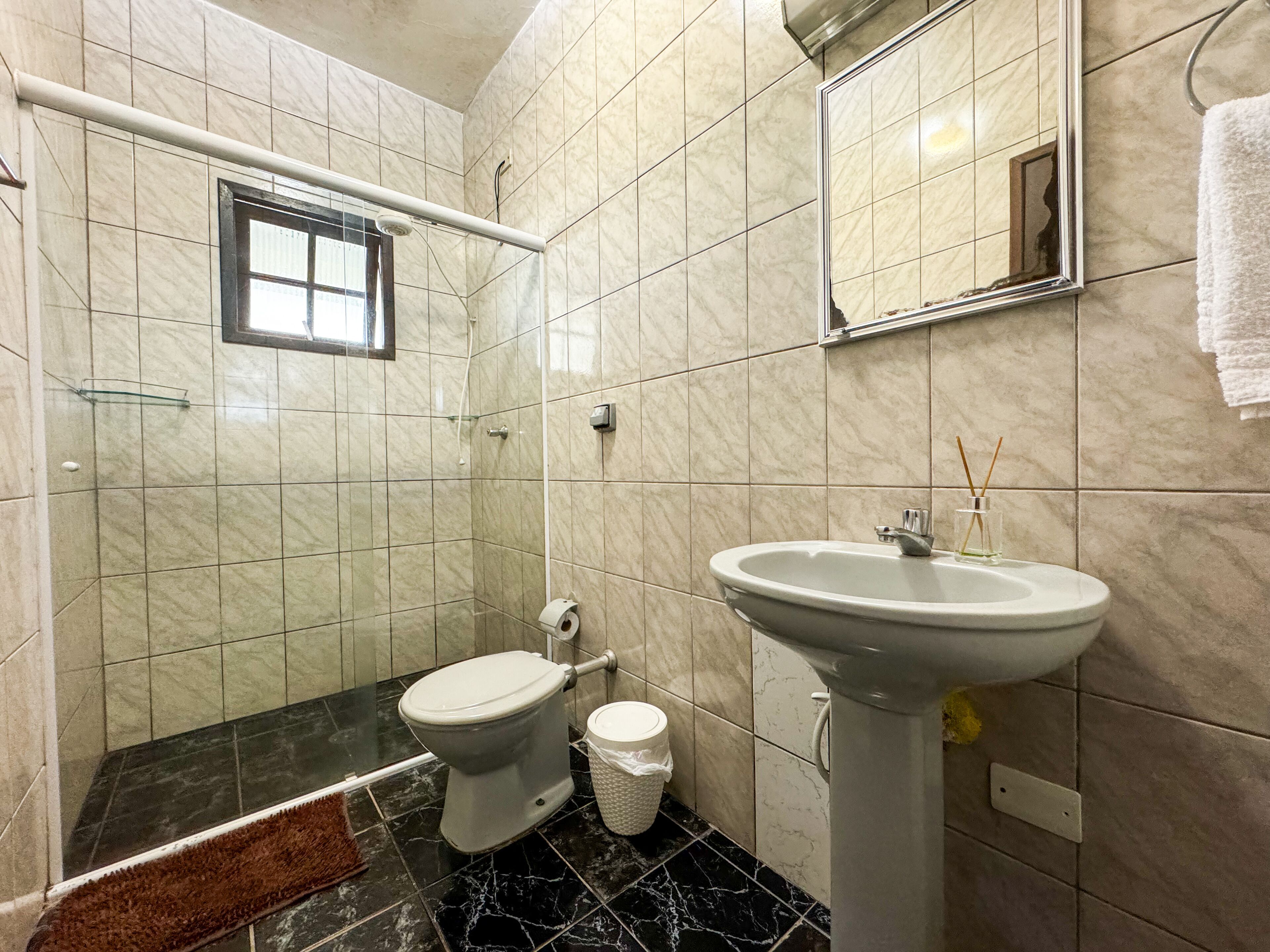 A bathroom with a toilet, sink, and shower.
