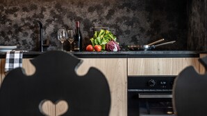 Eine Küche mit modernem Design, ausgestattet mit einer Holzausziehtheke, einem Herd und einem Spülbecken.