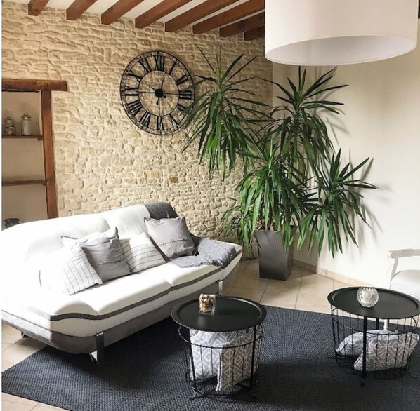 Relax in this inviting living room with a sofa, round table, and potted plant.