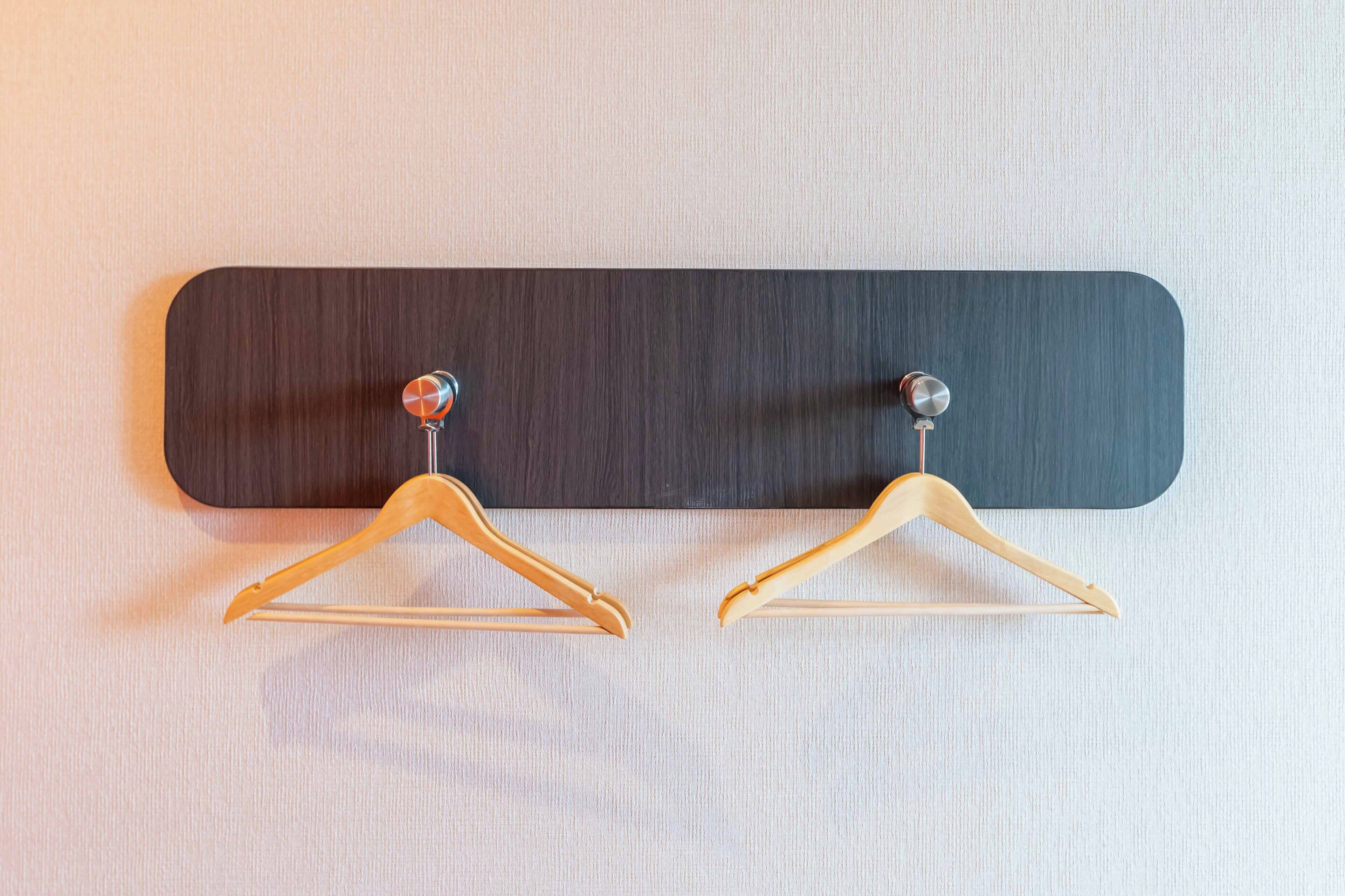 Un panel de madera con dos ganchos de madera.