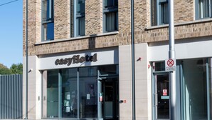 A modern building with a glass entrance, a sign reading 'easyhotel,' and a no parking sign.