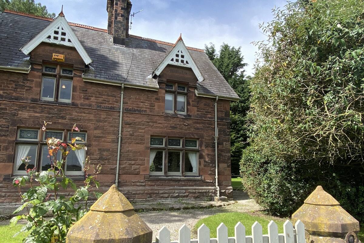 A stone building with a traditional design, featuring a sign that reads "PFA" and a sign above the entrance that says "Rural Cottages".