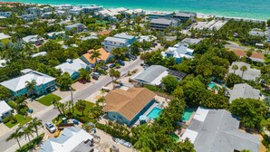 An aerial view of a coastal residential area with houses, a swimming pool, and a beach. - Updated Home with Outdoor Dining and heated Pool! 2 Minutes to Beach! - Native S (Holmes Beach)