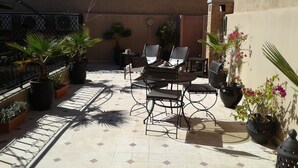 A patio with a tiled floor, outdoor furniture, and potted plants. - Unforgettable stay in Marrakech (Marrakesh)