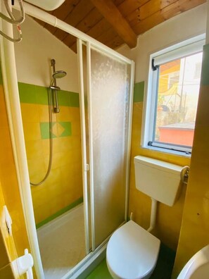 A small bathroom with a shower, toilet, and a window. - Duplex Studio Casetta San Giovanni (Pizzo)