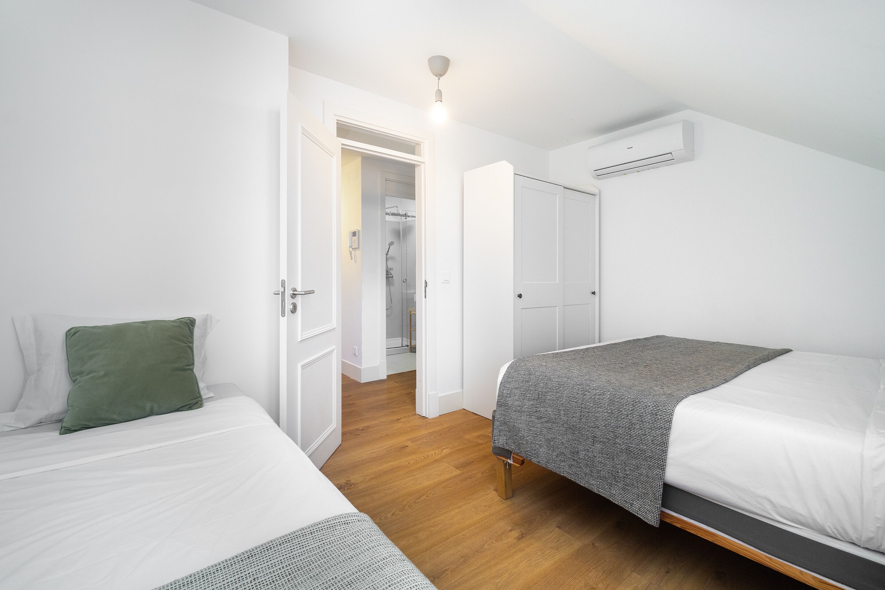 Une chambre avec deux lits, un dressing et un espace douche.