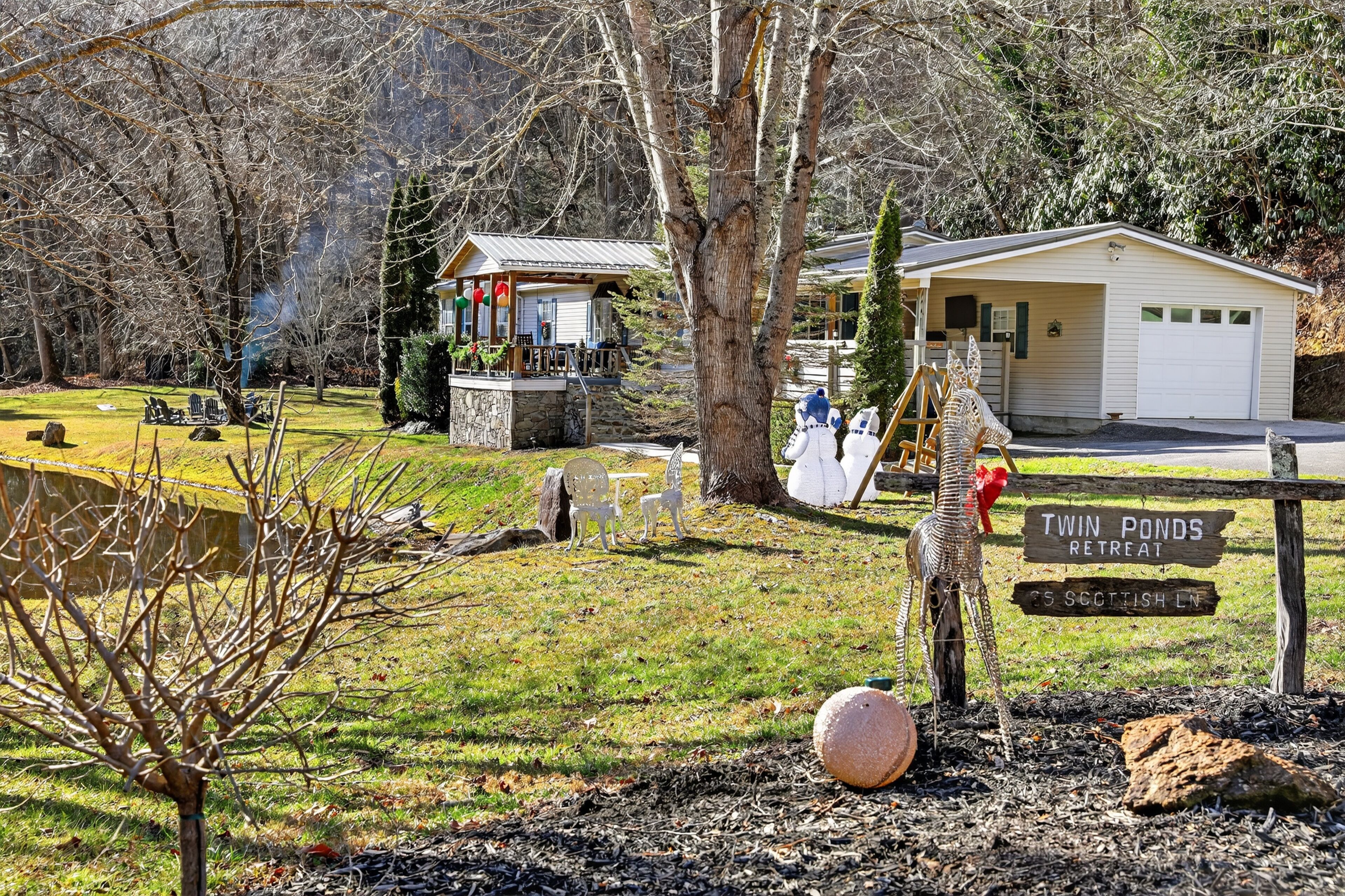 Un chalet doté d’une terrasse en pierre, d’une plateforme en bois et d’un panneau indiquant « Twin Ponds Retreat ».