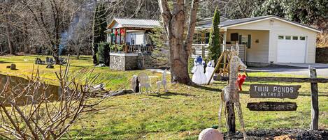 Un chalet doté d’une terrasse en pierre, d’une plateforme en bois et d’un panneau indiquant « Twin Ponds Retreat ».