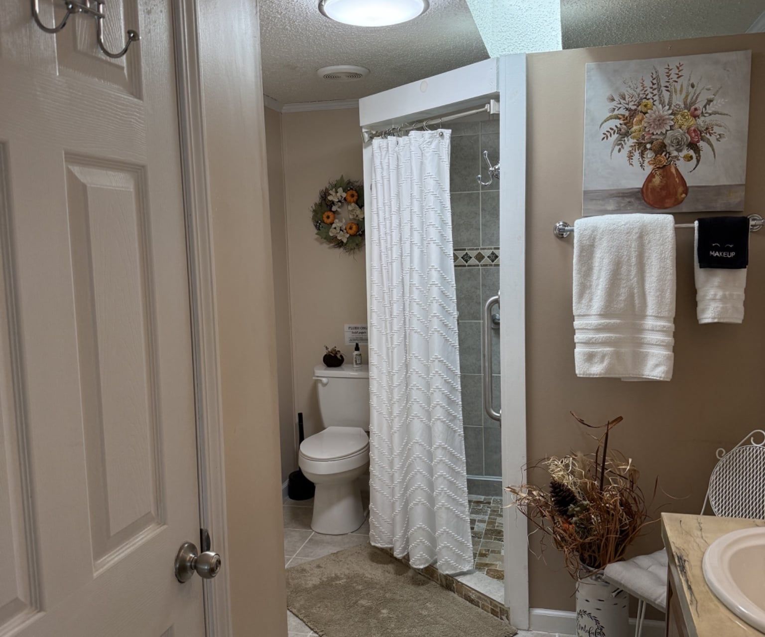 A bathroom with a shower, toilet, and sink.