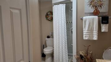 A bathroom with a shower, toilet, and sink.