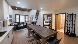 Een moderne keuken met een houten eettafel, zwarte stoelen en een inbouwoven.