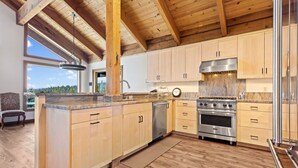 A modern kitchen with wooden cabinets, stainless steel appliances, and a large island. - AMAZING VIEWS- MODERN HOME- SH #14 by Bear Valley Vacation Rentals (Arnold)