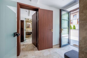 A modern interior with a wooden door leading to a bathroom and a glass door to an outdoor area. - Separé v Zahradě (Ratmerice)