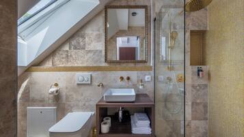 A modern bathroom with a skylight, a glass-enclosed shower, a vanity with a sink, and a toilet.